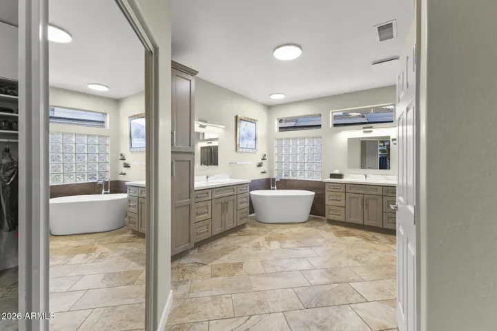 The ensuite bath has new cabinetry, quartz countertops, split vanities, a large soaking tub, a large walk-in closet, tiled walk in shower, custom fixtures and lighting - feels just like a spa.