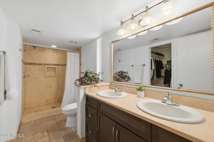Featuring double sinks, a walk-in closet and a custom tile walk-in shower, this primary bathroom is ready to make your own!
