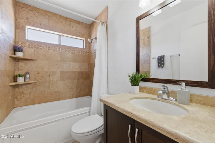 Updated with custom tile shower and executive height counters, this bathroom even has a sneaky linen closet behind the door for more storage!