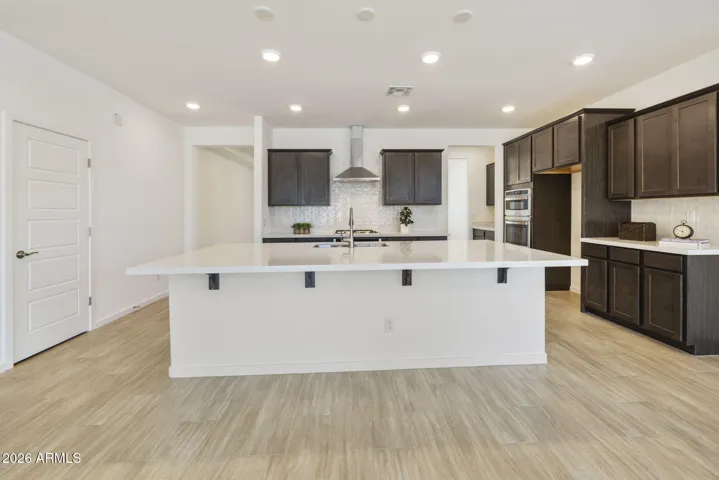 GOURMET KITCHEN WITH BUILT-IN APPLIANCES, STAGGERED CABINETS, QUARTZ COUNTERS AND A DESIGNER BACKSPLASH.