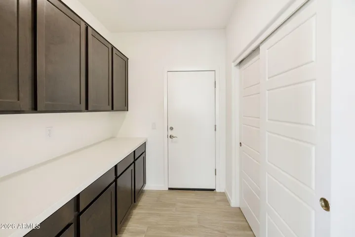 OWNER'S ENTRY FROM GARAGE HAS A LARGE STORAGE AREA AND UPPER AND LOWER CABINETS