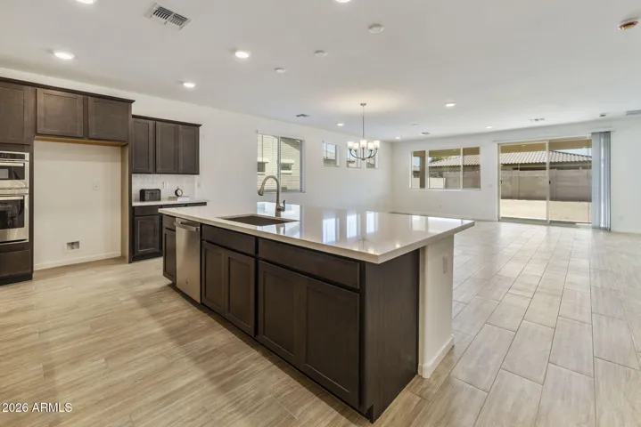 GOURMET KITCHEN WITH BUILT-IN APPLIANCES, STAGGERED CABINETS, QUARTZ COUNTERS AND A DESIGNER BACKSPLASH.