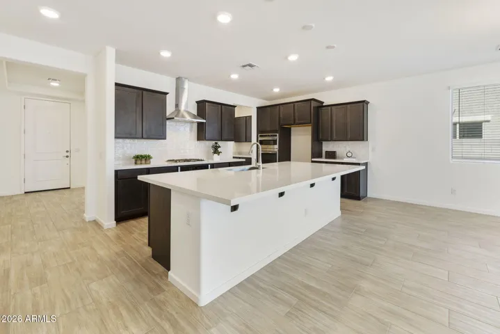 GOURMET KITCHEN WITH BUILT-IN APPLIANCES, STAGGERED CABINETS, QUARTZ COUNTERS AND A DESIGNER BACKSPLASH.