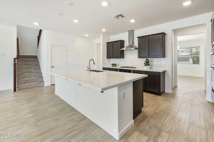 GOURMET KITCHEN WITH BUILT-IN APPLIANCES, STAGGERED CABINETS, QUARTZ COUNTERS AND A DESIGNER BACKSPLASH.