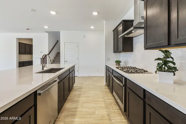 GOURMET KITCHEN WITH BUILT-IN APPLIANCES, STAGGERED CABINETS, QUARTZ COUNTERS AND A DESIGNER BACKSPLASH.