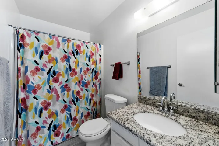 Guest bathroom with granite countertop and tub/shower.