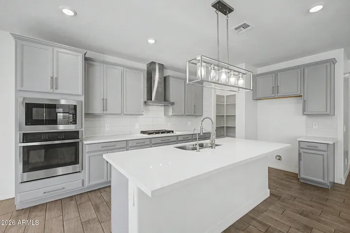 Beautiful kitchen with gas cooktop and matching stainless steel appliances.