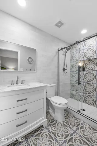 Primary Suite Bathroom - Tile work done in 2025 and glass shower door.