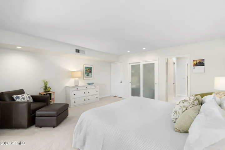 pacious owner’s suite with cozy sitting area, updated finishes, modern closet doors, and a bright open layout designed for comfort and relaxation.