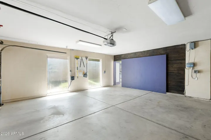 Oversized Scottsdale garage with extra storage, bright overhead lighting, durable concrete flooring, and direct access to the home.