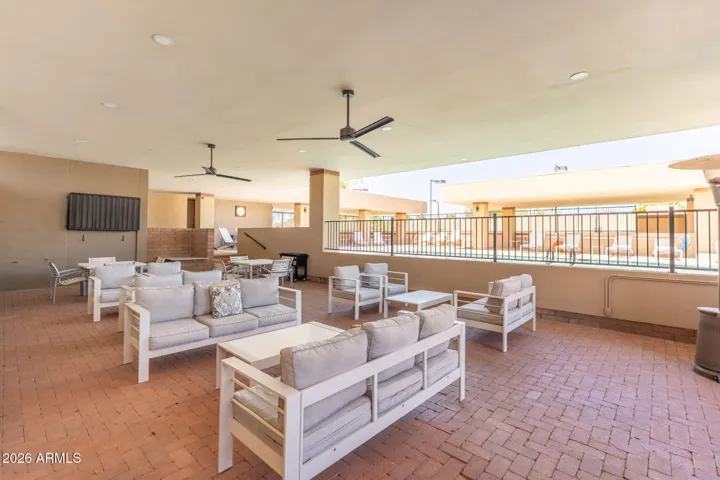 Scottsdale community lounge with covered seating, ceiling fans, outdoor entertainment space, and comfortable gathering areas overlooking the pool.