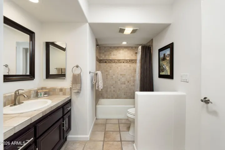 Stylish Scottsdale bathroom with tiled shower surround, updated vanity cabinetry, modern fixtures, and warm neutral finishes for a spa-inspired feel.