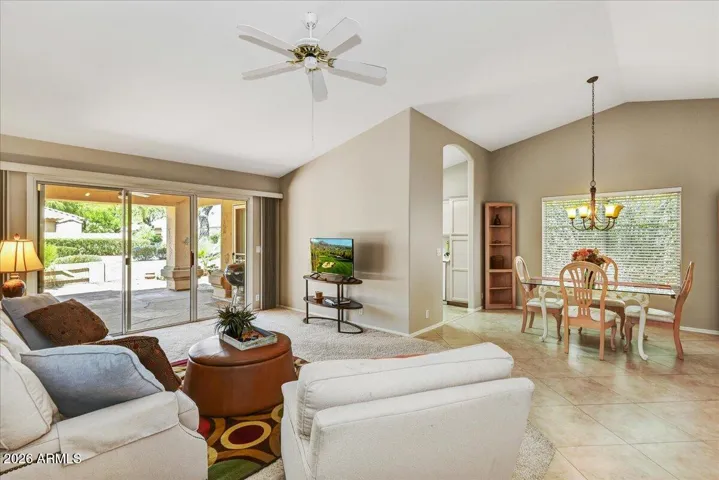 The expansive great room boasts dramatic vaulted ceilings and stylish tile flooring, flooded with natural light.