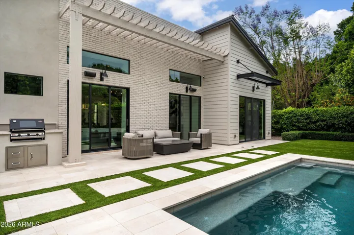 Backyard Featuring Heated Pool with Built in Barbecue and Seating Area