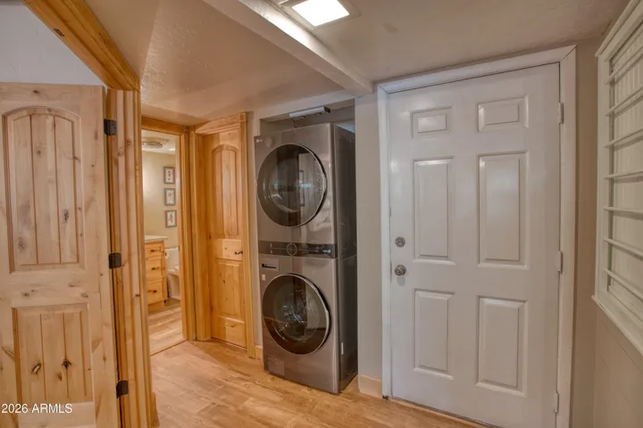 Hallway to main bedroom and bath, stackable laundry and pantry closet.