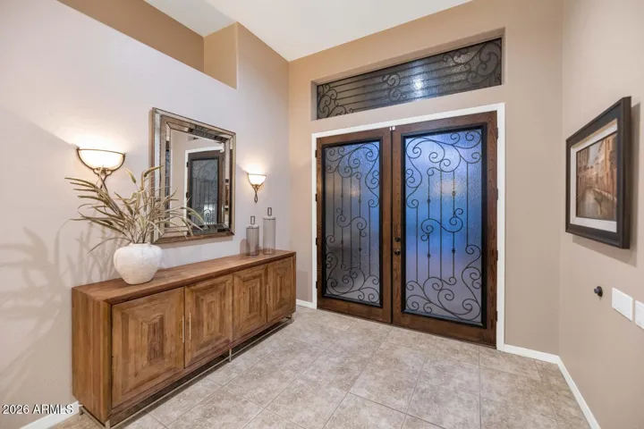 Obscure glass and iron front door at entry.