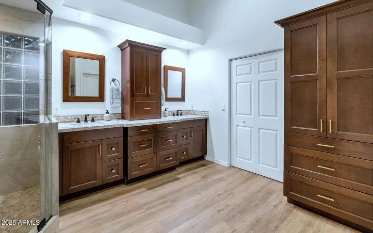Plenty of space with dual sinks, custom cabinets, quartz countertops, decorative tile & updated light fixtures.