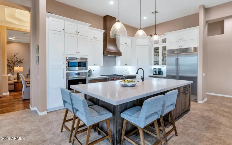 Quartzite countertops, 10' kitchen island with bar seating, storage & hidden electric outlets.