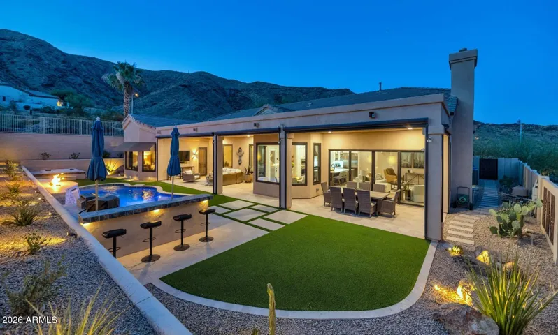 Plenty of outdoor space with HUGE covered patio (can be enclosed with sun shade), travertine tile, outdoor kitchen, pebble tech pool with water & fire feature, faux grass and spa.