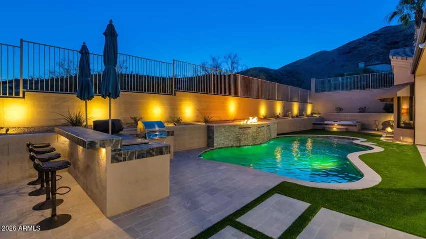 Outdoor bar & grill area with built-in stainless steel cooler, custom lighting & additional dedicated natural gas line (Pizza oven does NOT convey at close)