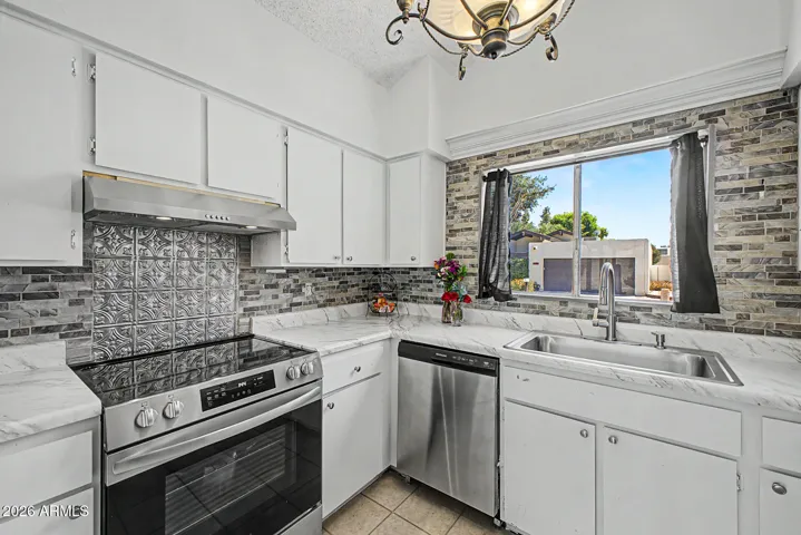 Cute kitchen in white/grey includes all stainless steel appliances.