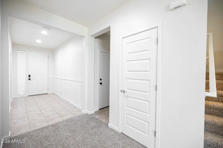Front door to left, Garage walkway and mouse hole closet near stairs