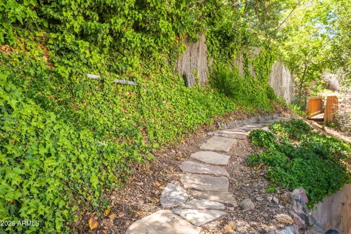 Sweet little path behind the house leading to a bridge/path to upper level additional parking
