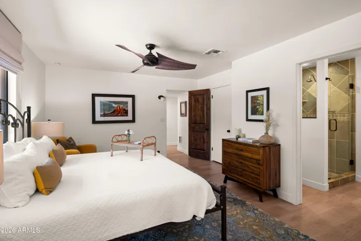 Spacious primary bedroom with a large window and peaceful ambiance