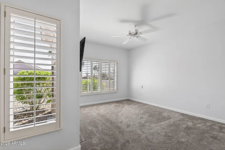 45 GUEST BEDROOM WITH PLANTATION SHUTTERS AND WALL MOUNTED TV.