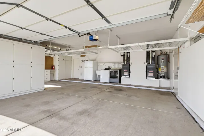 63 FULL SIZED 2 CAR + GOLF CAR GARAGE WITH ATTACHED CABINETS & LAUNDRY.