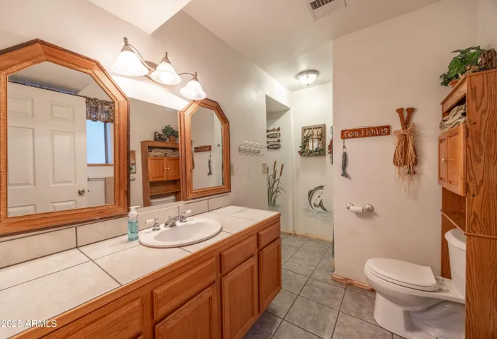 Primary Suite Bathroom with shower and linen storage area.