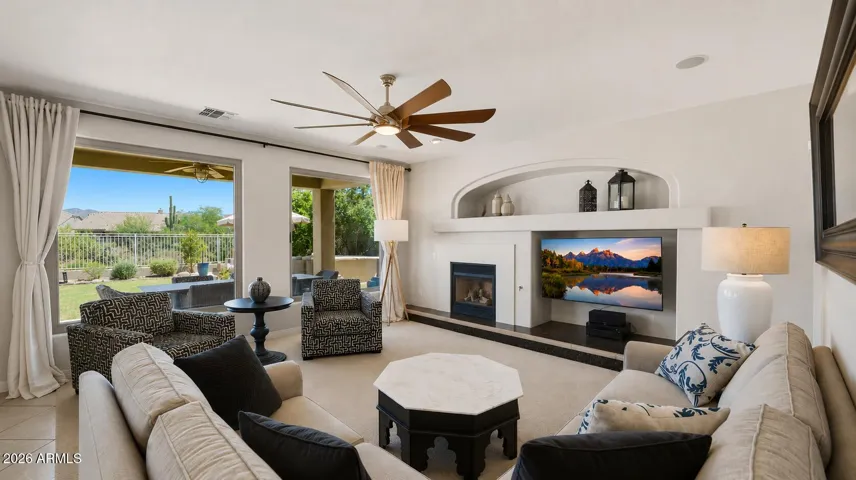 Family room just off the kitchen with a fireplace and large windows overlooking the backyard.