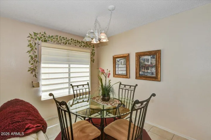 A dedicated dining area illuminated by an elegant overhead light fixture, situated perfectly between the living area and kitchen for seamless entertaining.