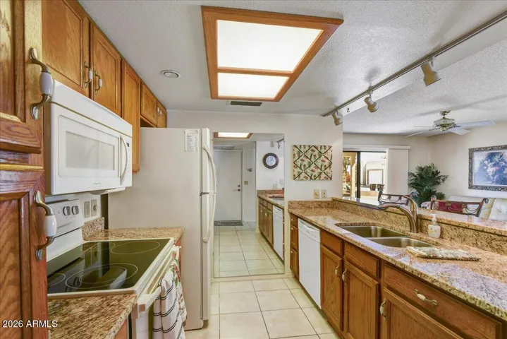 A functional kitchen layout equipped with wood cabinetry and granite countertops