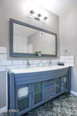 Custom dual vanity sinks with in this custom cabinet base, updated plumbing fixtures and lighting too!