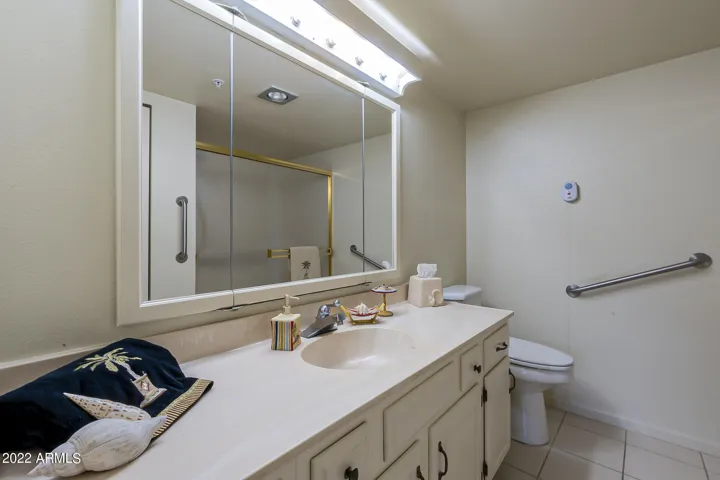 Master bathroom with emergency pull cord, heat lamp, shower with seat and cool tile flooring.