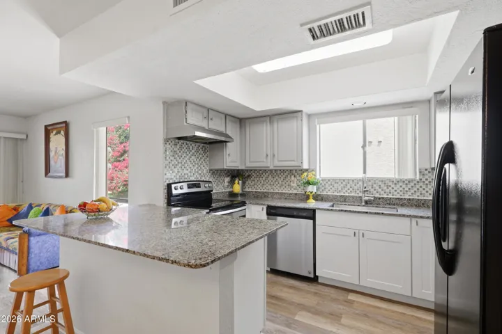 Remodeled kitchen has new countertops, backsplash, and sink.