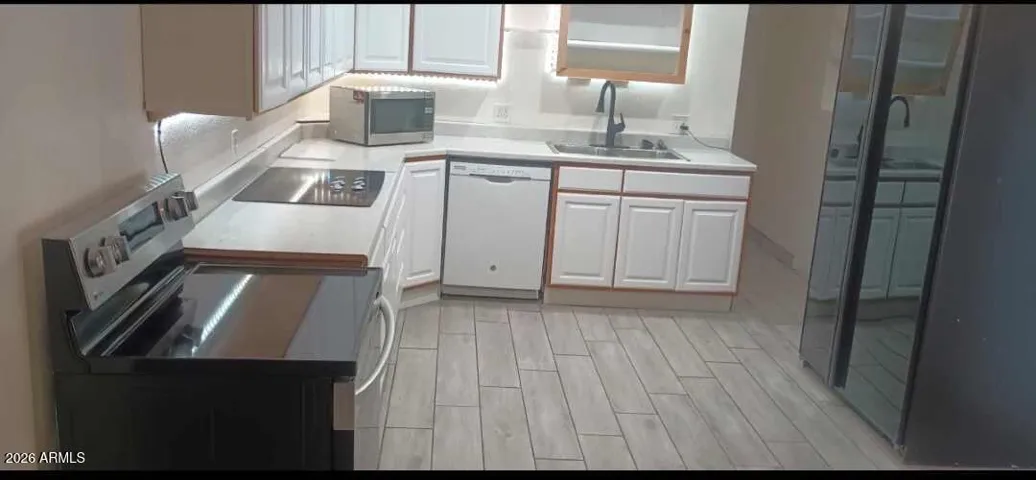 Remodeled kitchen with new range oven & plank wood like flooring, 42 inch side by side Kitchenaide refrigerator