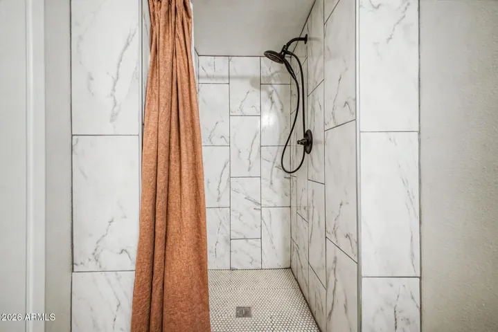 primary bathroom with floor to ceiling tile shower