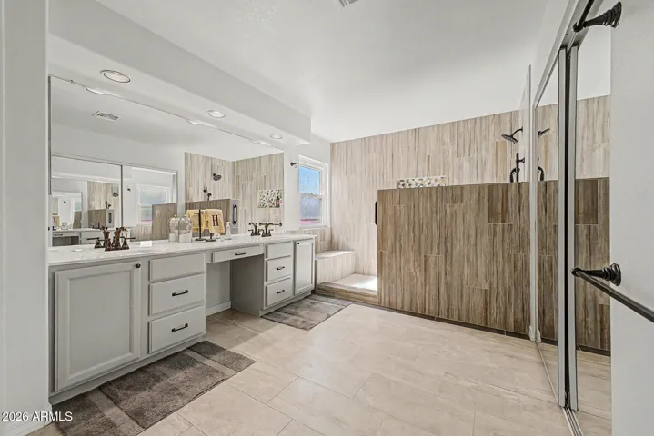 Primary bathroom with seated vanity area and oversized floor-to-ceiling tile shower!