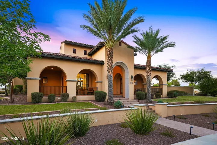 Beautiful Tuscan inspired curb appeal with mature landscaping, paver driveway, and custom architectural details.