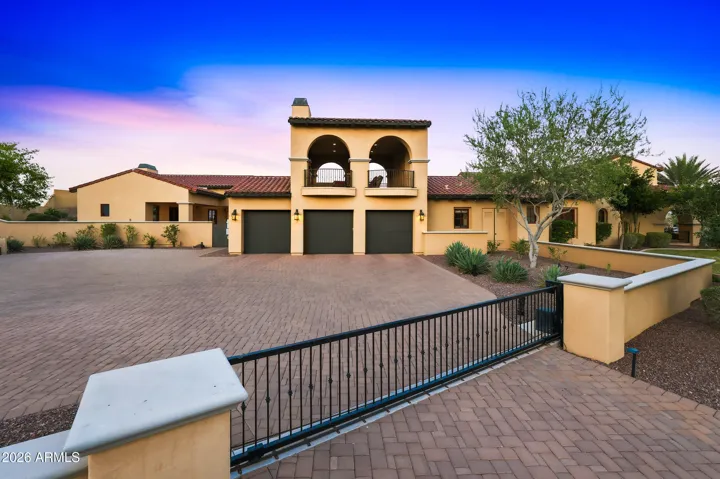 Gated parking area with extended paver driveway and plenty of space for additional vehicles.