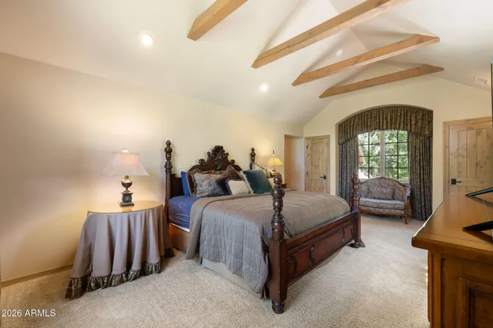 secondary primary bedroom upstairs with vaulted ceilings and views of the golf course