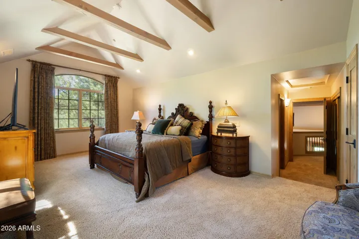 secondary primary bedroom upstairs with vaulted ceilings and views of the golf course