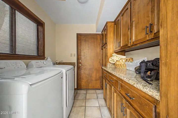 Laundry Room with Lots of Storage Cabinets and Granite Counter Top.
