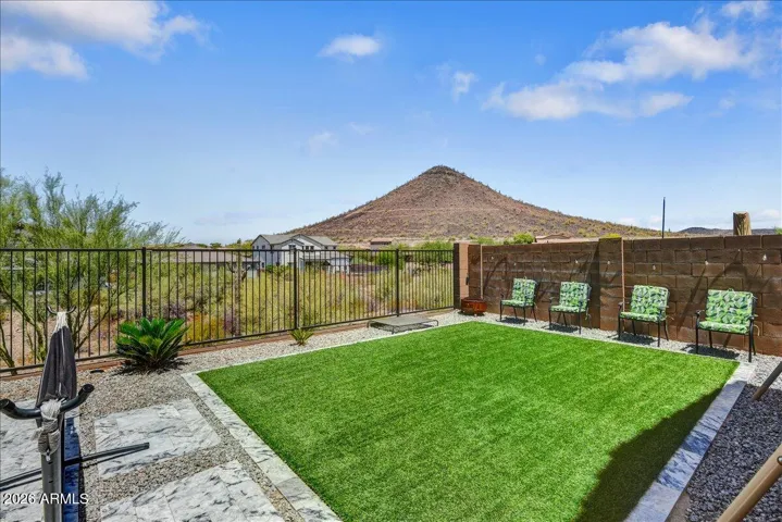 This vantage point showcases the yard's open, airy feel, bordered by sleek view fencing that looks out toward the surrounding landscape. Featuring a perfect mix of durable turf and modern hardscaping, the space feels private yet expansive.