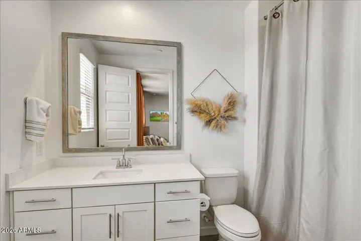This modern upstairs bathroom serves as the private en-suite to the adjacent bedroom. It features a crisp white vanity with ample cabinet storage, a large mirror, and updated lighting. Finished in bright neutral tones with durable flooring, this clean and functional space offers excellent convenience and privacy for guests or family members.
