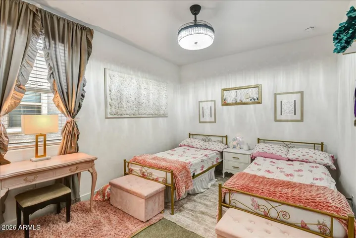 This charming upstairs bedroom features a bright, clean aesthetic with neutral walls, a stylish hanging pendant fixture, and a versatile layout. It offers an excellent footprint for a bedroom suite, hobby room, or private study.