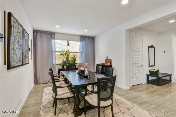 An elegant, dedicated dining area with modern tiled flooring and a neutral color scheme. Perfectly positioned adjacent to the main living areas, it provides an open yet distinct space for hosting dinners and family gatherings.