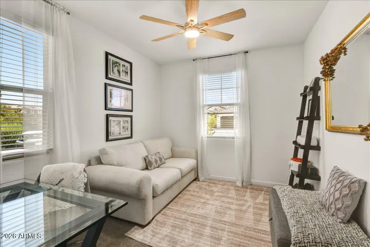 Located downstairs, this comfortable bedroom features a classic neutral palette, a cooling ceiling fan, and great natural light. It offers a highly versatile layout perfect for a secondary bedroom, a guest suite, or a private home office.